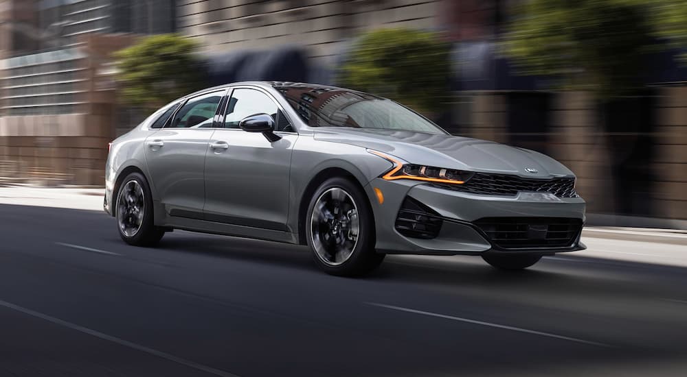 A grey 2021 Kia K5 is shown from the front at an angle.