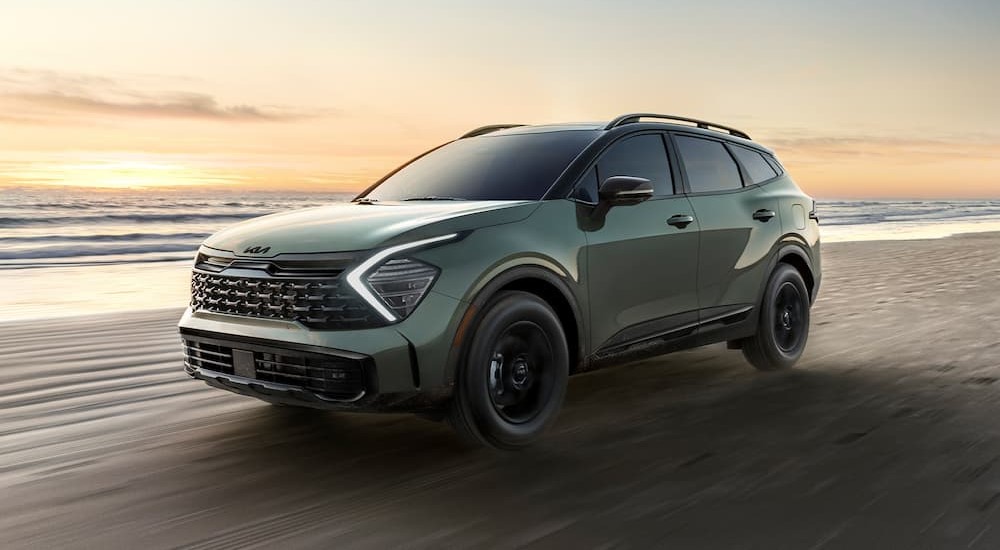 A green 2025 Kia Sportage X-Pro Prestige driving off-road.