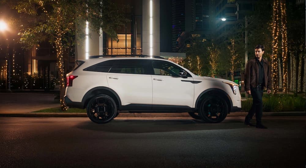 White 2025 Kia Sorento for sale parked in a city at night.