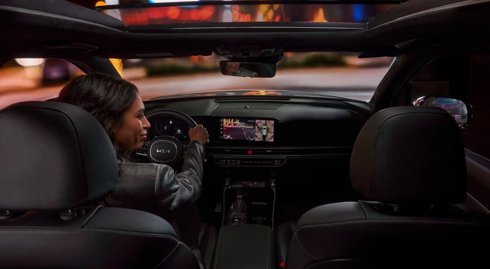Woman driving in a 2025 Kia Sorento at night.