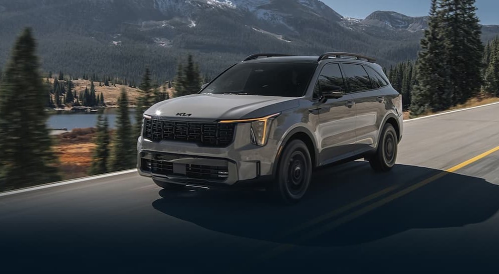 A gray 2025 Kia Sorento for sale driving on a highway.