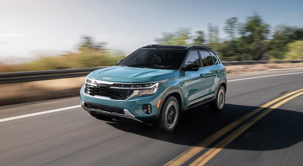 A blue 2025 Kia Seltos driving on a highway.