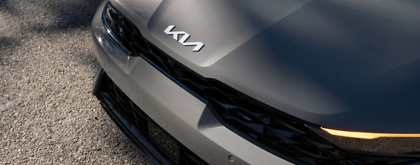 The hood and headlights on a grey 2025 Kia K5 at a Kia dealer near Elk River.