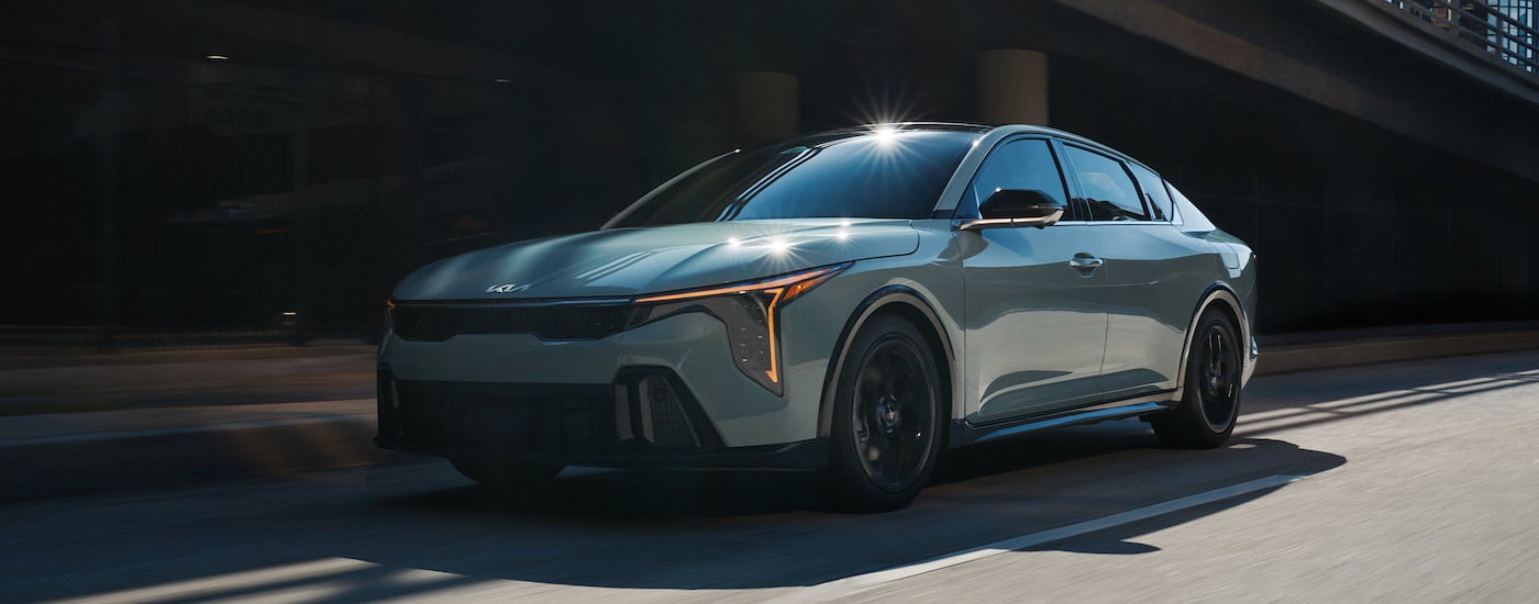 A grey 2025 Kia K4 is shown from the front at an angle after leaving a Kia dealer.