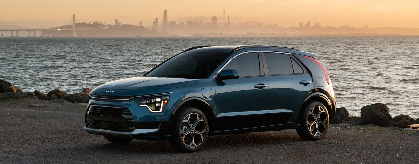 A blue 2025 Kia Niro PHEV is shown from the side.