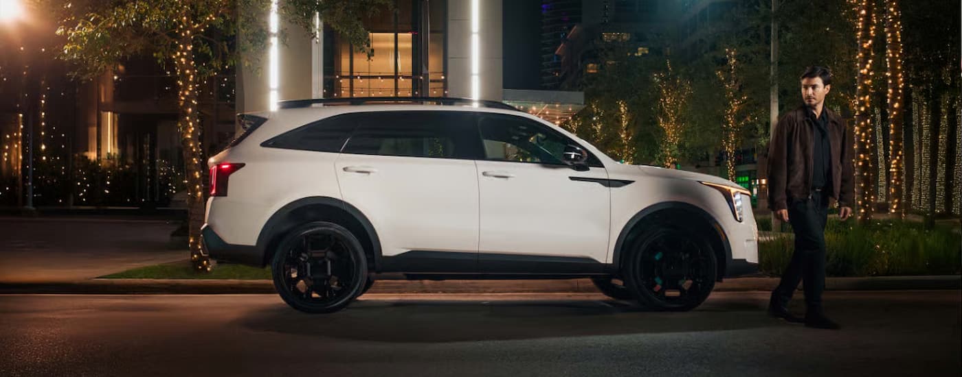 A white 2025 Kia Sorento driving down a city street